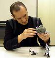 A photograph of Kaneko inspecting the figures